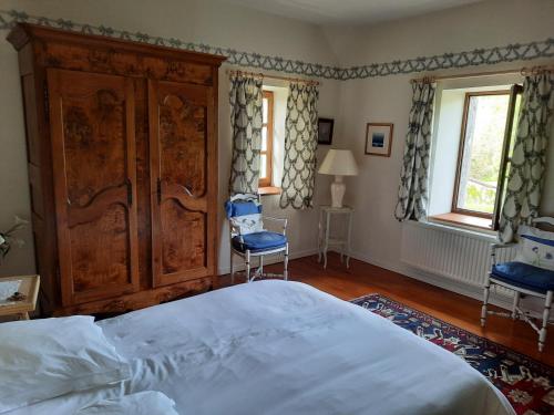 une chambre avec un lit et une chaise dedans dans l'établissement Chambres d'hôtes Le Moulin Juste Ambierle - Loire, à Ambierle