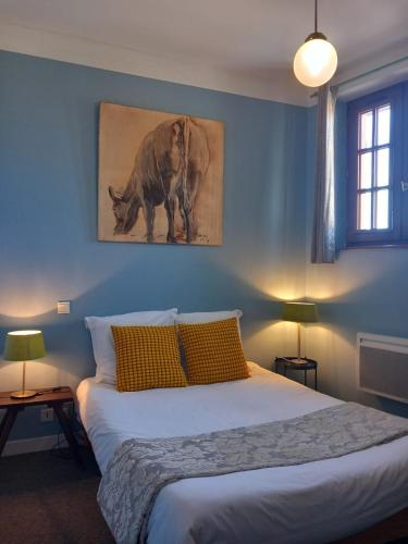 - une chambre bleue avec un grand lit et des oreillers jaunes dans l'établissement Hostellerie du Chateau Bellenaves, à Bellenaves