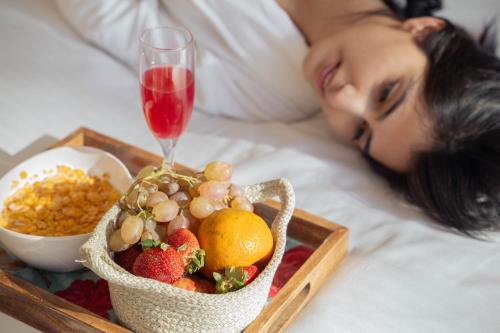 una donna sdraiata su un letto con un vassoio di frutta di PerfectStayz B2L Hills Tapovan a Rishikesh