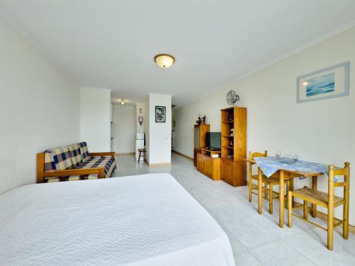 a bedroom with a bed and a dining room at Apartamentos Turisticos Perola da Rocha in Portimão