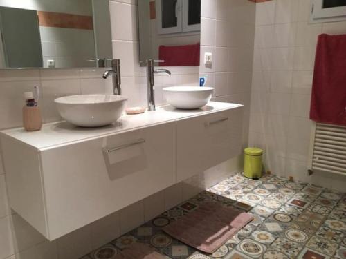a bathroom with two white sinks on a counter at Au Murmure des Cascades in La Roque-sur-Cèze
