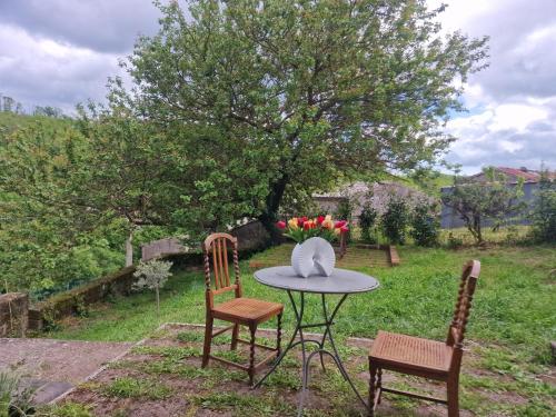 a table with two chairs and a table with flowers on it at Le Terrazze della Tuscia in Latera