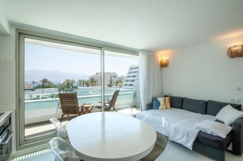 een woonkamer met een bank en een tafel bij Sea Side Dream-Amazing sea view best location in town in Eilat