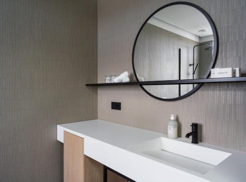 een badkamer met een wastafel en een spiegel bij Hotel Lotus in Reykjavík