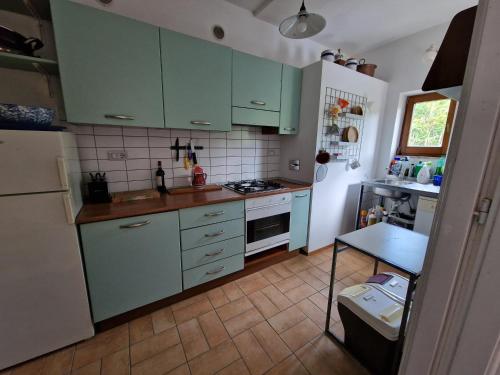 a kitchen with green cabinets and a table in it at Le Terrazze della Tuscia in Latera