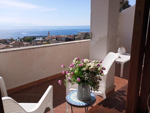 a vase with flowers on a table on a balcony at Scario house in Scario