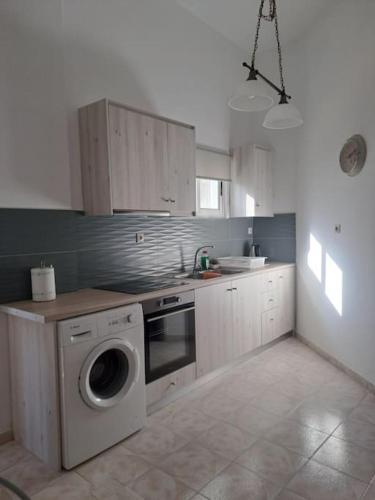a kitchen with a washing machine in a kitchen at Flisvos Home Studio in Megalochori