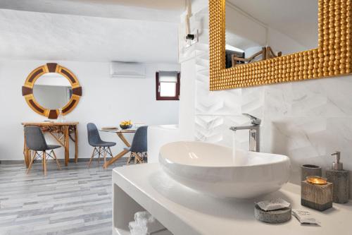 ein weißes Badezimmer mit einem Waschbecken und einem Spiegel in der Unterkunft Skinopi Fisherman's Dream in Schinopi
