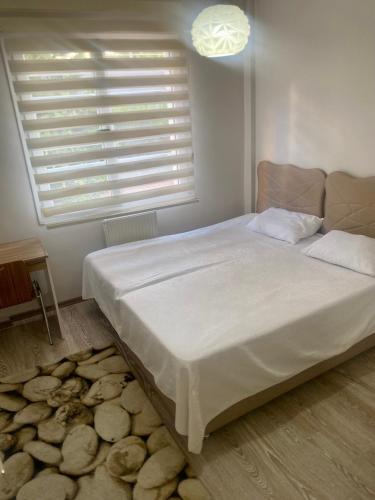 een slaapkamer met een groot wit bed en een raam bij ARGEUS PRESTİJ in Kayseri