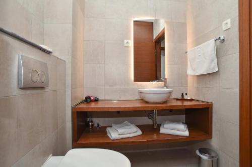 a bathroom with a sink and a toilet and a mirror at New Chill and Go Apartments in Budva
