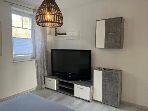 a living room with a flat screen tv on a entertainment center at Ferienwohnung Tina in Burgkunstadt