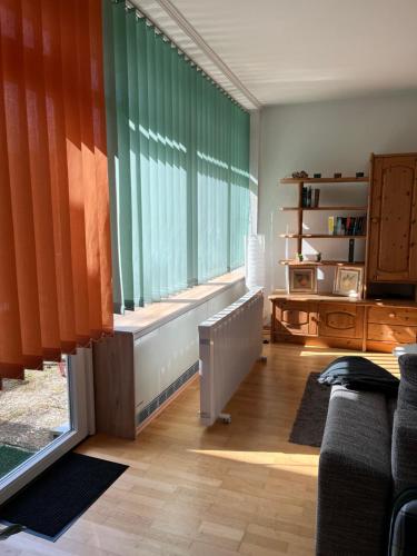 una sala de estar con una gran ventana con cortinas de color naranja en Zum Sieck Müden-Örtze, en Faßberg