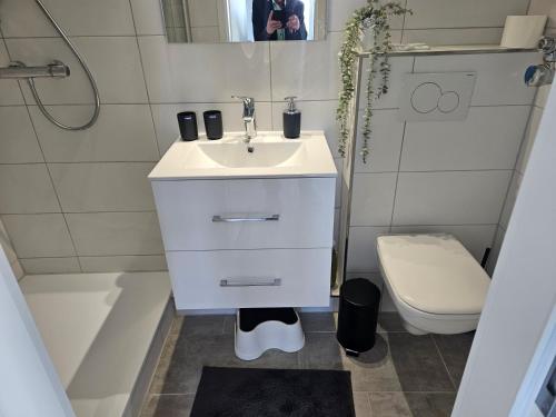 a white bathroom with a sink and a toilet at Vier Jahreszeiten Haus 3 Whg 24 in Großenbrode