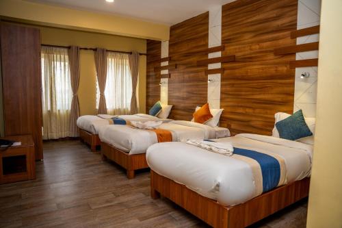 eine Reihe Betten in einem Zimmer mit Holzwänden in der Unterkunft Hotel Glory Garden in Pokhara