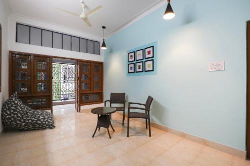 Super OYO JANAPATH INN في Khandagiri: غرفة معيشة فيها طاولة وكراسي