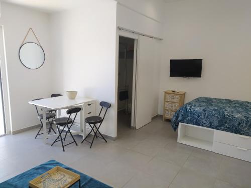 une chambre avec un lit, une table et des chaises dans l'établissement Vacance location mer piscine var sud terrasse, aux Issambres