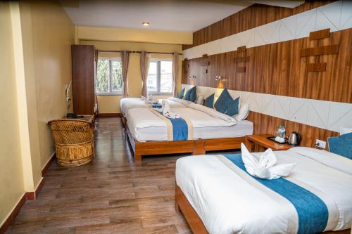 a hotel room with three beds in a room at Hotel Glory Garden in Pokhara