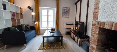 a living room with a blue couch and a fireplace at Studio vue Cathédrale Laon in Laon