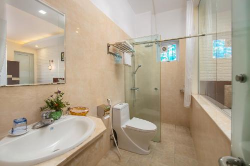 a bathroom with a sink and a toilet and a shower at New Airport In & Suites in Hanoi