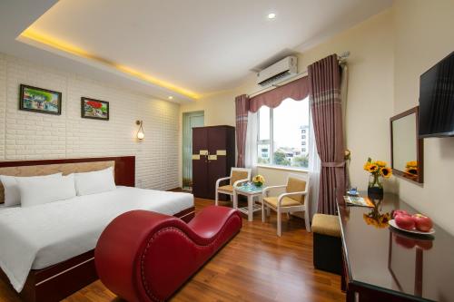 um quarto de hotel com uma cama e uma cadeira vermelha em New Airport In & Suites em Hanói