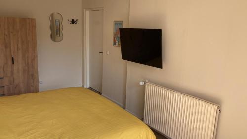 a bedroom with a bed and a tv on the wall at Logement 1860 in Nieuw-Amsterdam