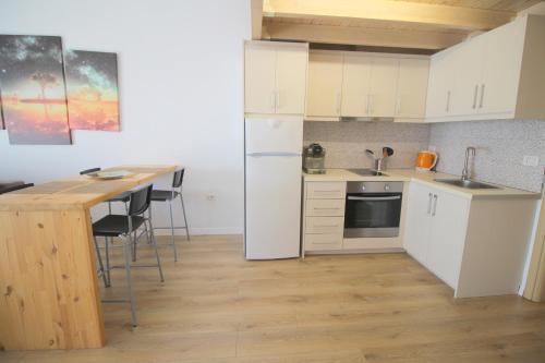 a small kitchen with white cabinets and a table at Blue Residence in Sarandë