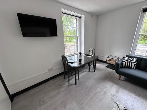 a living room with a table and a couch at The Penruddocke Arms in Dinton