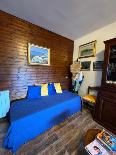 1 dormitorio con cama azul y pared de madera en Casa Angelo en Palau