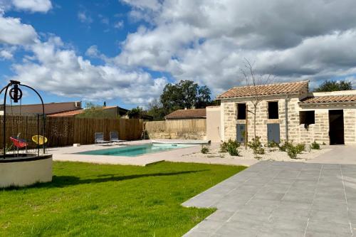 une cour arrière avec une piscine et une maison dans l'établissement GROOMI The winegrower- Swimming pool bowling alley and air conditioning !, à Beaulieu