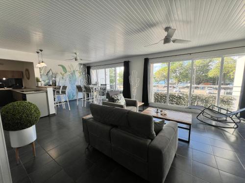 a living room with a couch and a table and a kitchen at BEACHFRONT Diamond Rock - Guest Suite with breakfast area OR Entire Apartment in Le Diamant