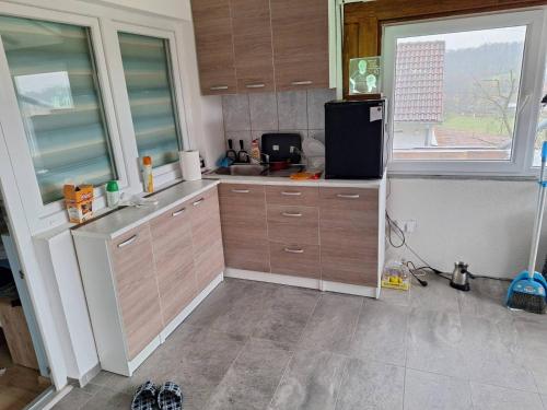 a kitchen with wooden cabinets and a sink and a refrigerator at Pedjin Kutak Brcko in Vražići