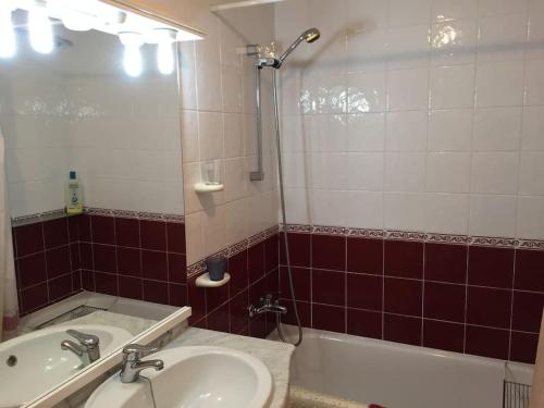 ein Badezimmer mit einem Waschbecken, einer Badewanne und einem Spiegel in der Unterkunft Apartamento acogedor playa Miramar in Miramar