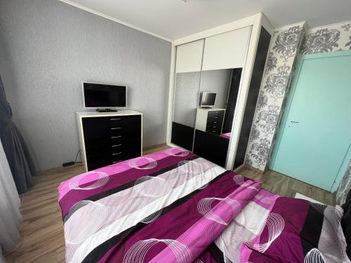 ein Schlafzimmer mit einem Bett und einem TV. in der Unterkunft Apartament Queen in Oradea