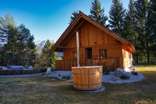 a log cabin with a barrel in front of it at Alpine Retreat Apartments Šurc in Rateče