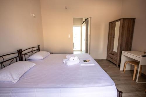 1 dormitorio con 2 toallas blancas en una cama en Elia Apartments en Agia Marina Aegina