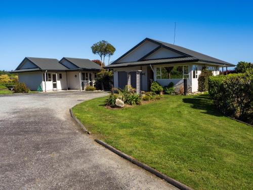 a house with a driveway in front of it at Karamea River Motels in Karamea