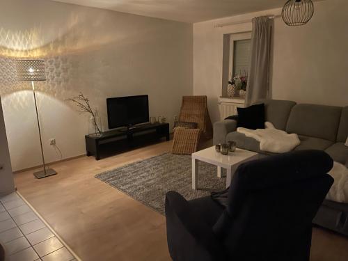 a living room with a couch and a tv at schöne Ferienwohnung in Meckenbeuren