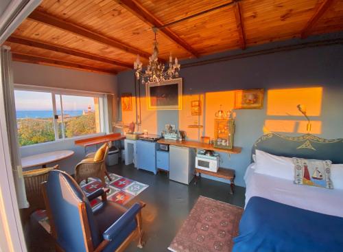 a bedroom with a bed and a desk and a kitchen at Agulhasbestview in Agulhas