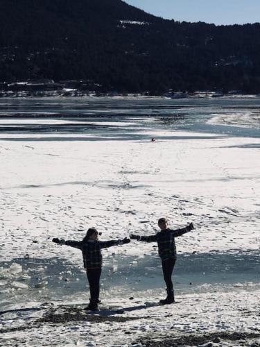 two people standing on a beach with their arms out at Chalet vue imprenable sur lac et pistes in Les Angles