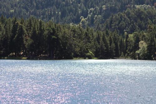 a large blue lake with trees in the background at Chalet vue imprenable sur lac et pistes in Les Angles