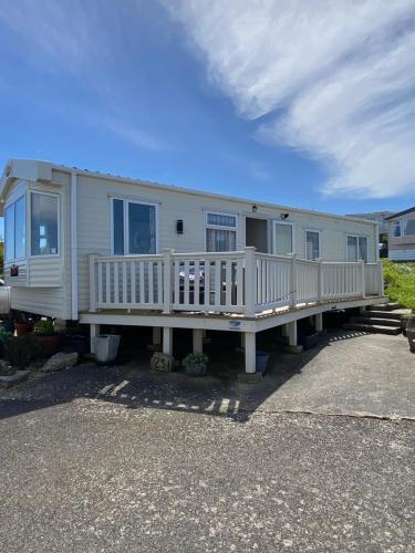 a mobile home with a porch and a deck at Stunning Caravan on Swanage Bay View Holiday Park in Swanage
