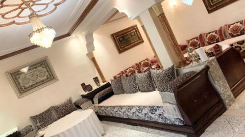 um quarto com uma cama e um lustre em 100% famille propre calme plus d’info 06 59 25 27 70 em Fez
