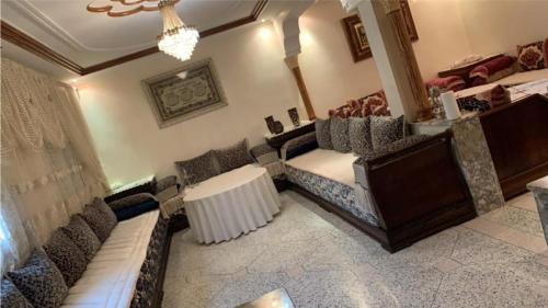 un salón con sillas y una mesa en una habitación en 100% famille propre calme plus d’info 06 59 25 27 70, en Fez