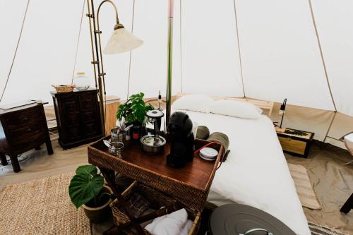 1 dormitorio con 1 cama y 1 mesa con mesita de noche en Luxe Glamping Tent in West-Friesland, en Venhuizen