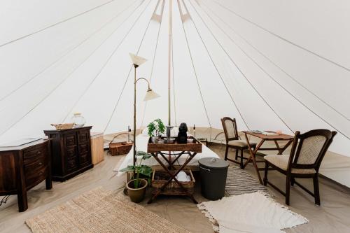 una habitación con una tienda de campaña con mesas y sillas en Luxe Glamping Tent in West-Friesland en Venhuizen