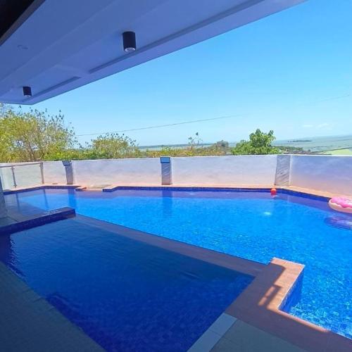 een groot blauw zwembad met uitzicht op de oceaan bij Jacobs Makiling Lakeview Resort in Los Baños