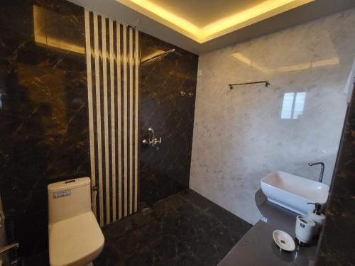 a bathroom with a toilet and a shower and a sink at Palm Crest The Colva Diaries in Colva