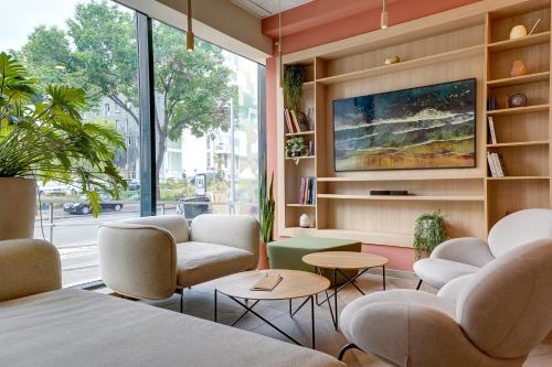 Habitación con sillas, mesas y TV. en Kyriad Marseille Palais Des Congrès – Vélodrome en Marsella