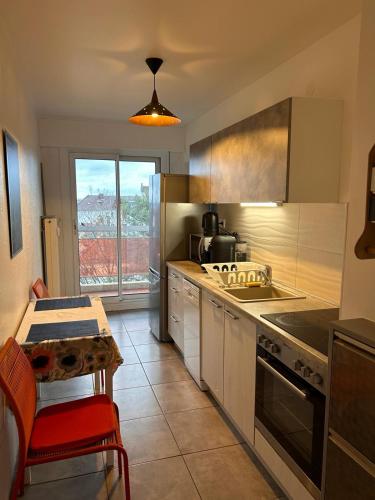 une cuisine avec un évier et une cuisinière four supérieur dans l'établissement Appartement sur les bords de l'Ill, à Strasbourg