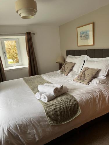 a bedroom with a white bed with towels on it at Eviedale Cottages in Evie